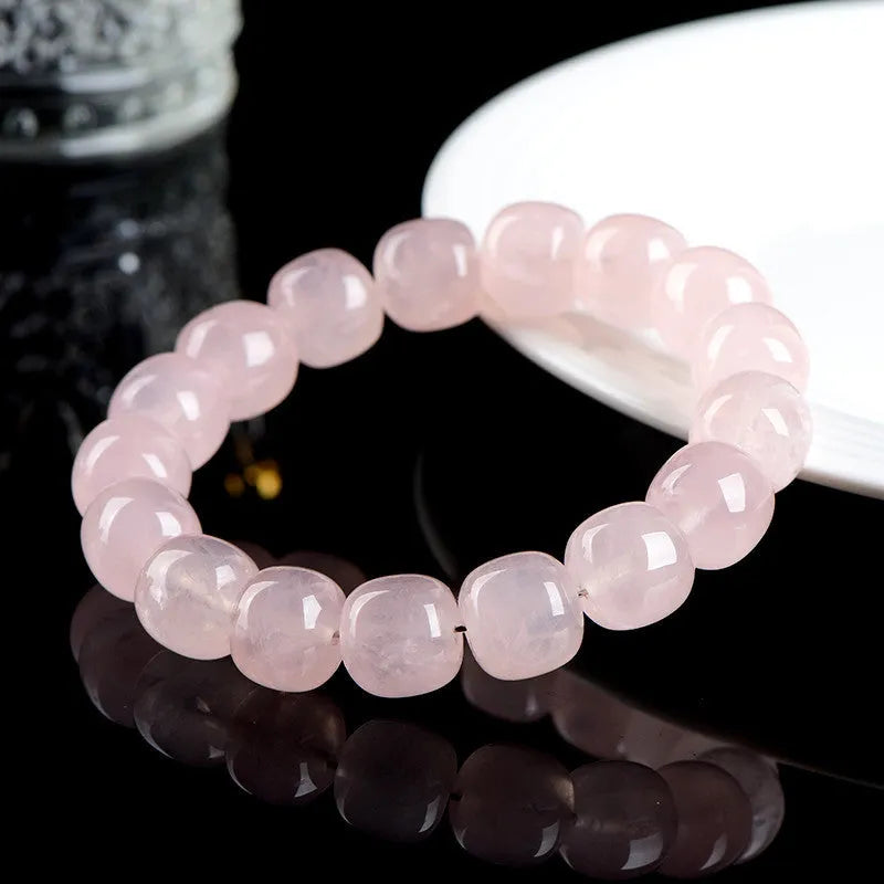 Natural pink crystal barrel bead bracelet with 11-12mm geometric design on wrist