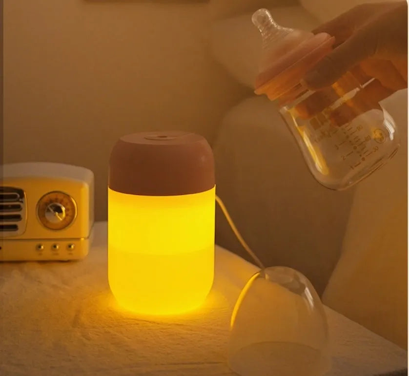 Small white cylindrical USB humidifier with charging cable for bedroom or desk use