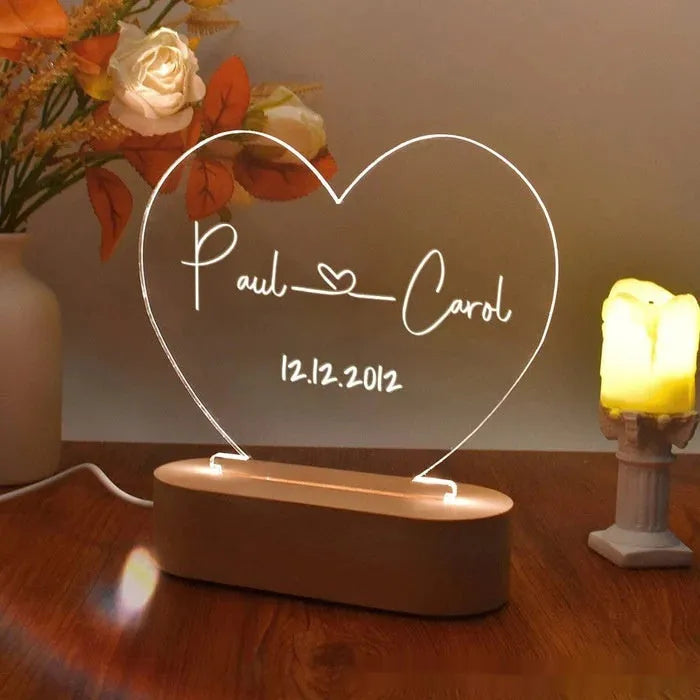 Custom transparent acrylic night light showing personalised names and date, lit by an LED base.