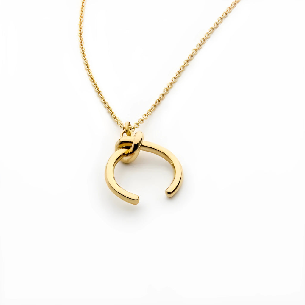 Geometric pendant necklace on an adjustable cross chain, shown in gold and silver electroplated finishes.