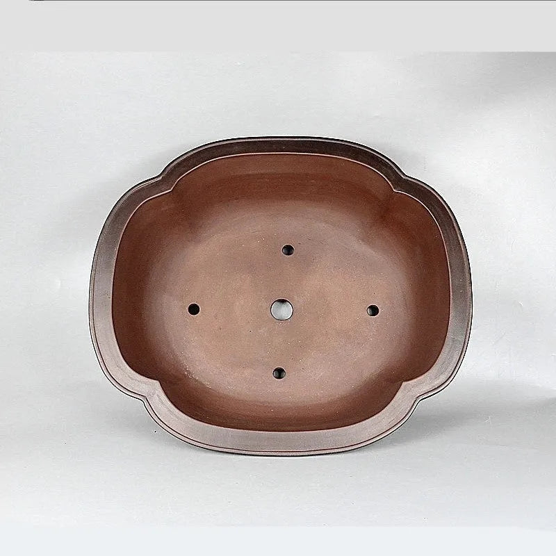 Handmade antique crabapple shaped purple clay flowerpot on a floor