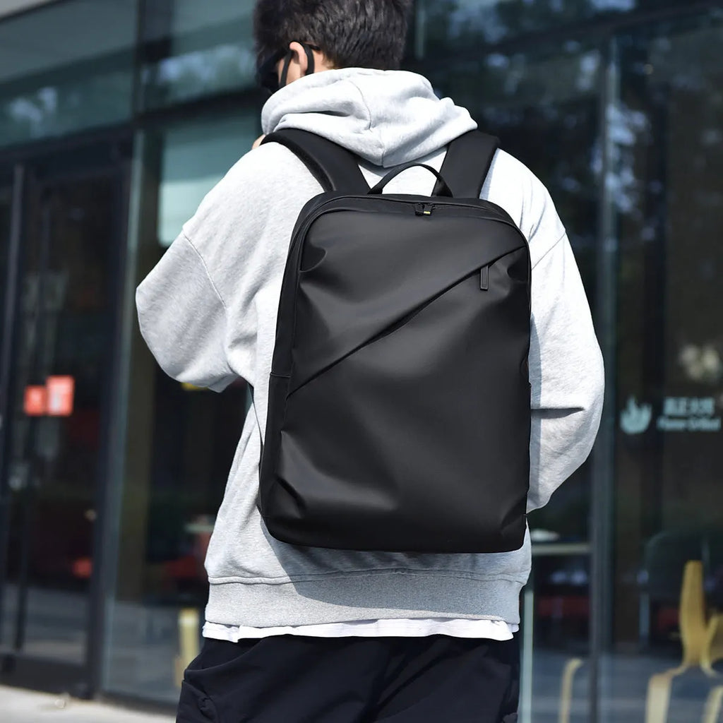 Large black waterproof PU leather backpack for men with prominent stitching, shown next to blue and grey colour options.