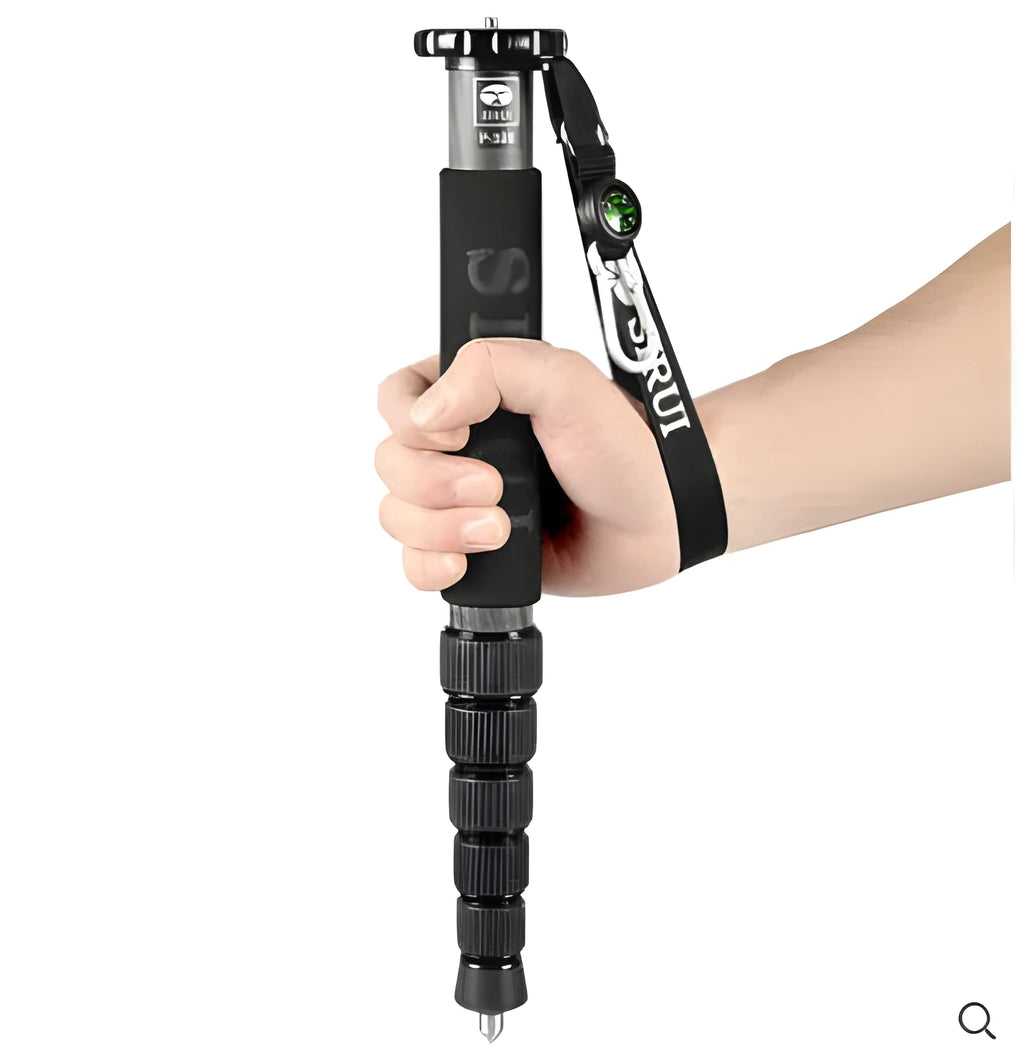 Black carbon fibre telescopic camera monopod fully extended to 1540mm next to an SLR