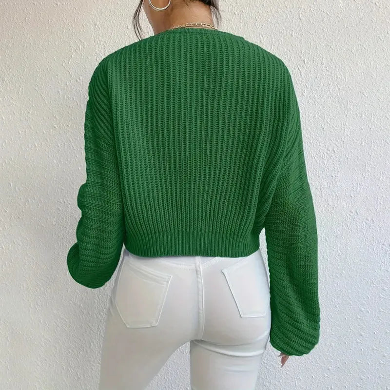 A woman's loose-fitting long sleeve pullover top in a solid colour.