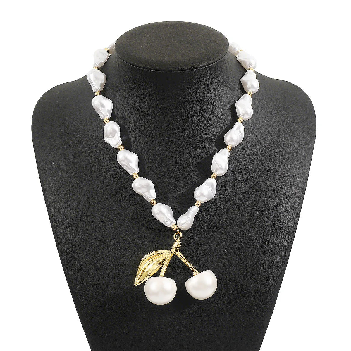 Gold geometric cherry fruit pendant on an adjustable white imitation pearl chain necklace.