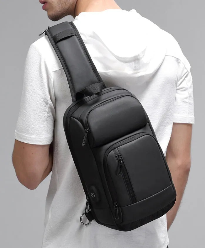 Black medium-sized PVC outdoor shoulder bag with an air cushion strap and internal organiser pockets.
