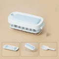 Blue high-capacity ice cube tray with lever mechanism and storage box containing an ice shovel.