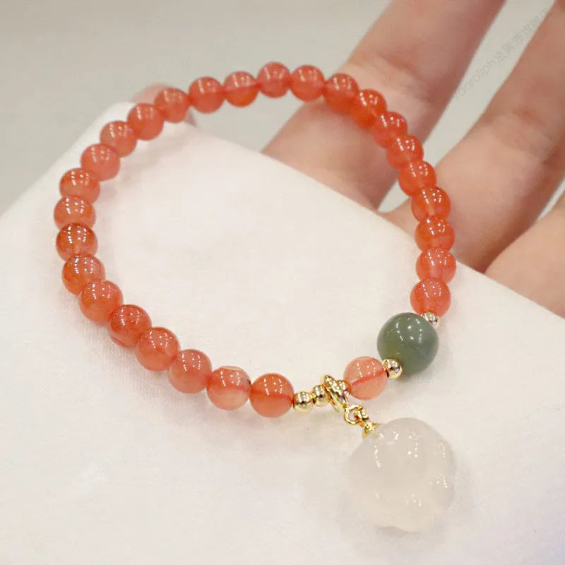 Natural red agate bracelet with jade beads and a Cat's Paw charm, showing 8mm agate beads and gem inlay detail.