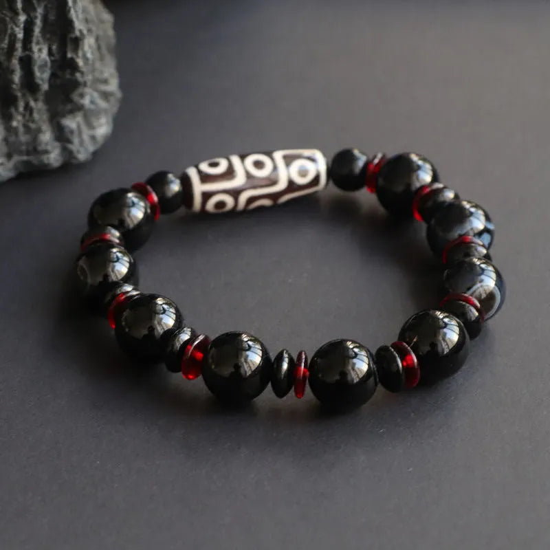 Black agate dzi bead bracelet with geometric 11mm beads on a hand-woven cord.