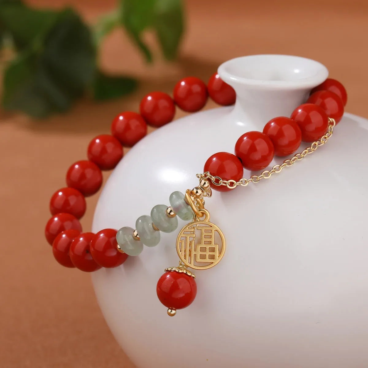 Handcrafted red sand cinnabar bracelet with fu character charm, jade spacer beads, and tassel decoration