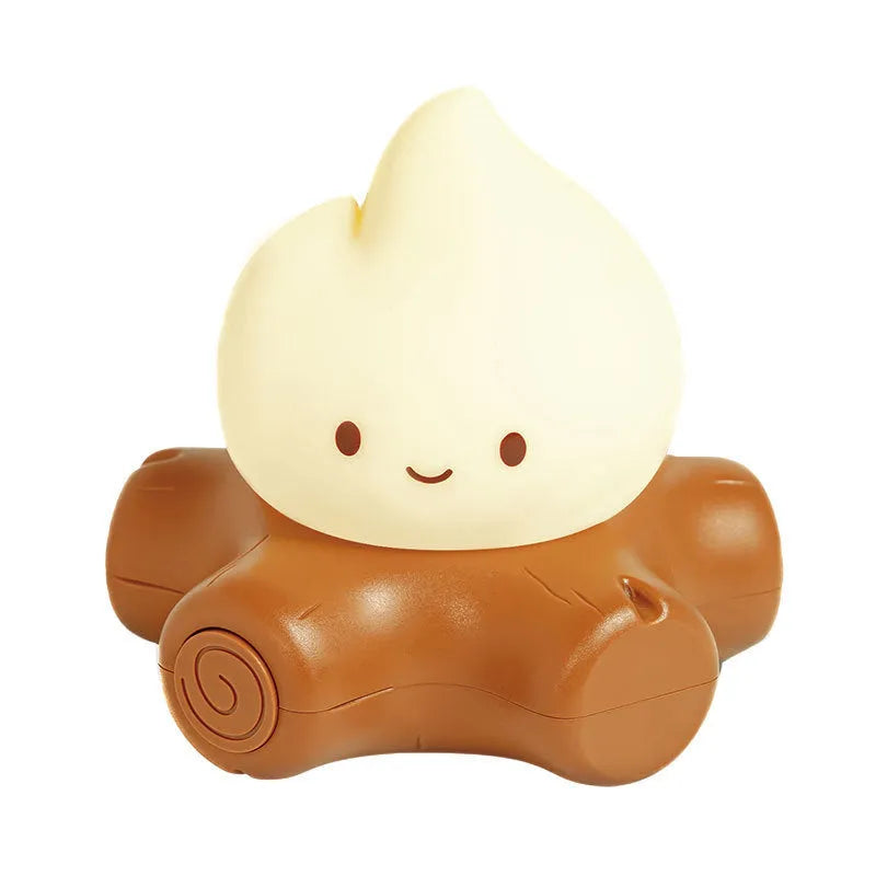 Small cartoon silicone fire pile night lamp with warm yellow lighting on wooden surface