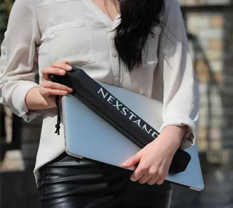 Black folding portable laptop stand made of reinforced nylon, shown folded to its compact size.