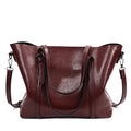 Retro style women's large capacity PU messenger bag in multiple colours on a table