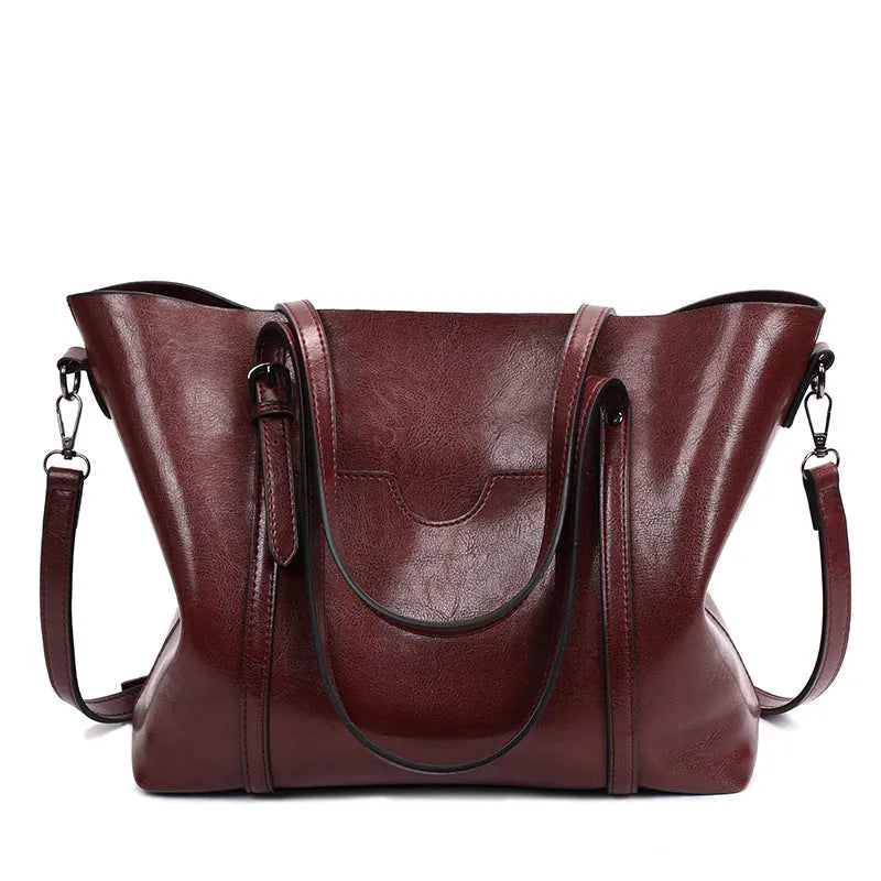 Retro style women's large capacity PU messenger bag in multiple colours on a table