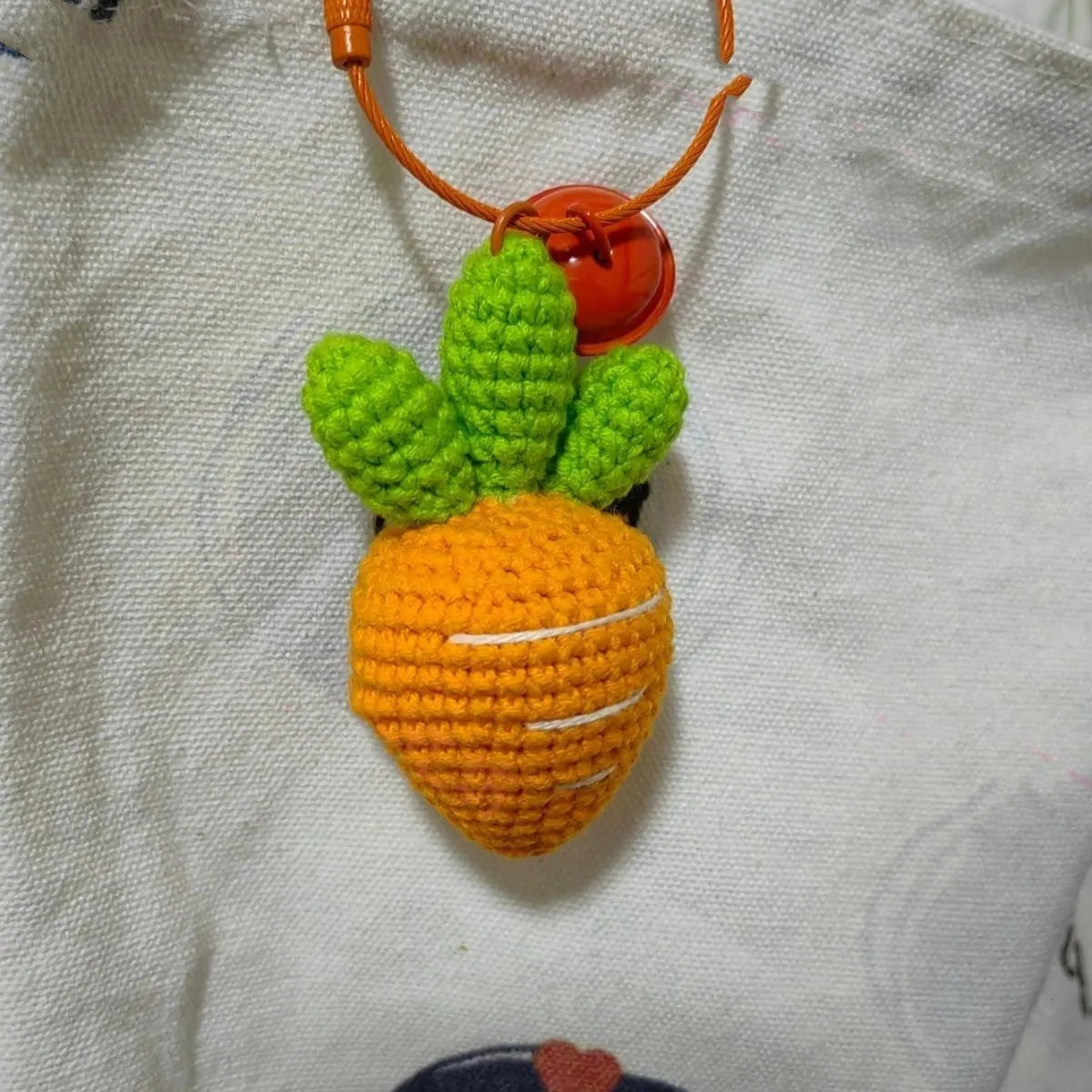 Soft wool cartoon carrot shaped keychain pendant on a keyring.