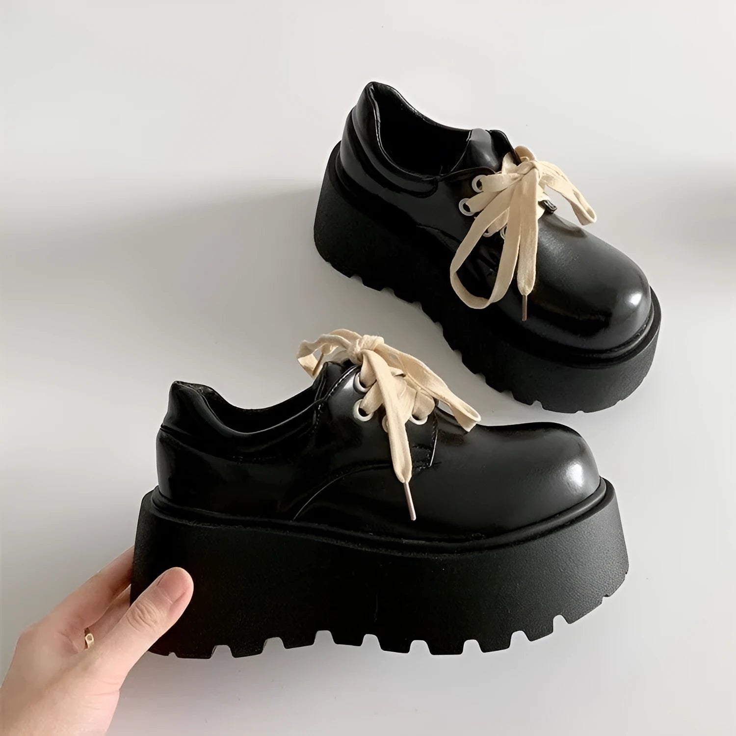 Black women's lace-up heels with a chunky rubber sole and a retro English muffin heel.