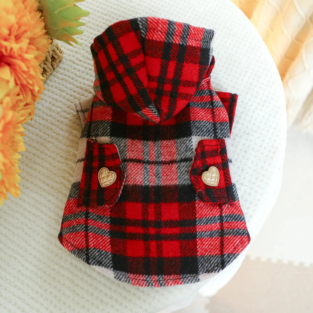 Red plaid trench coat for a dog, shown alongside a black houndstooth version, on a mannequin.