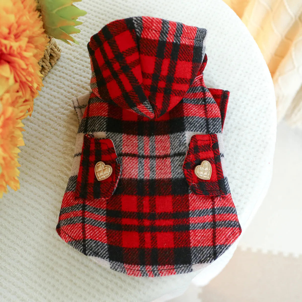 Red plaid trench coat for a dog, shown alongside a black houndstooth version, on a mannequin.