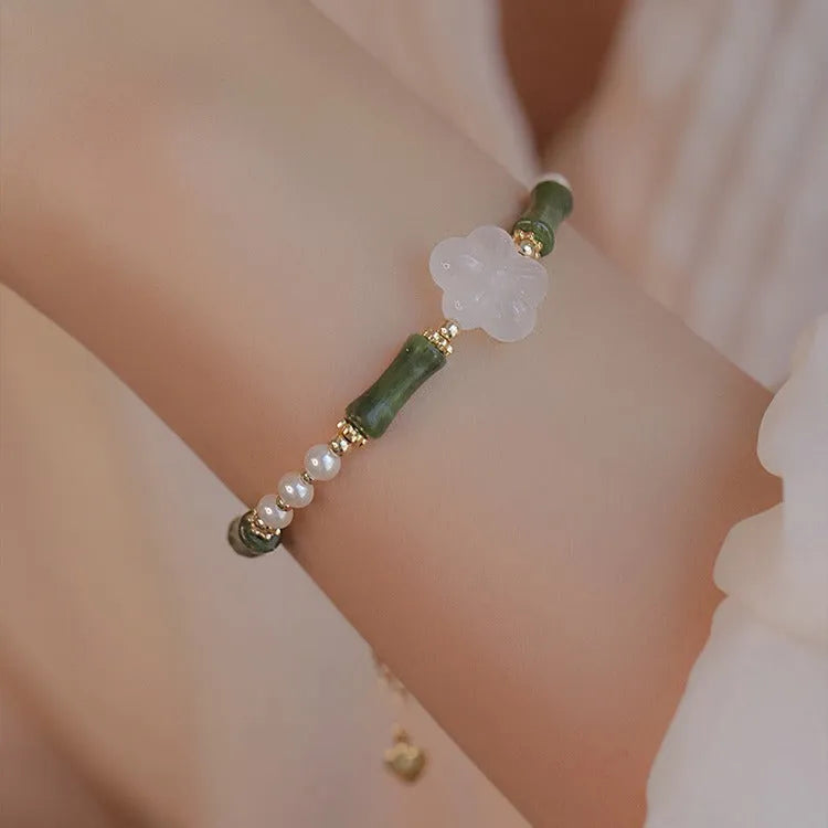 Handmade antique style bracelet with Hetian jade, copper shell pearls, and bamboo joint detail.