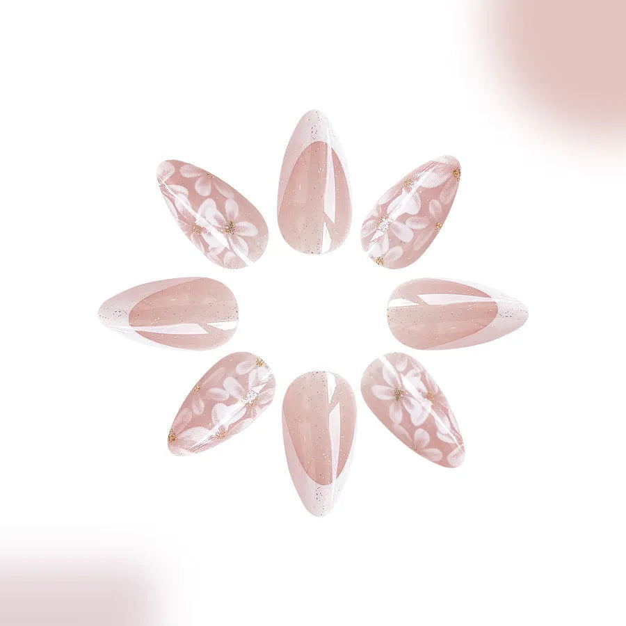 Short glossy almond artificial nails with French tip and glitter flower decorations