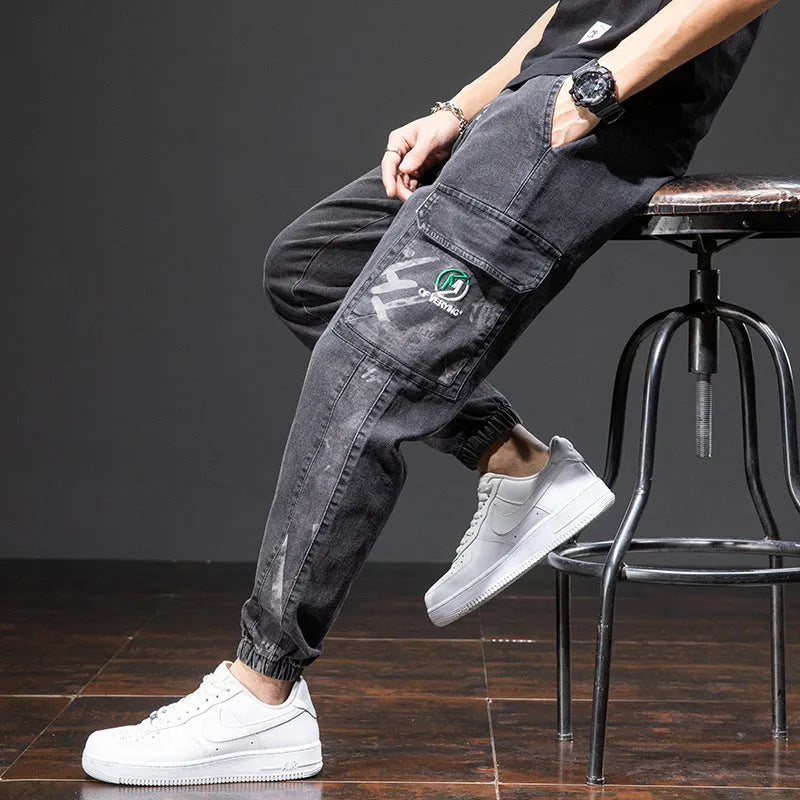 Men's loose fit straight leg cargo jeans in blue on a neutral background.
