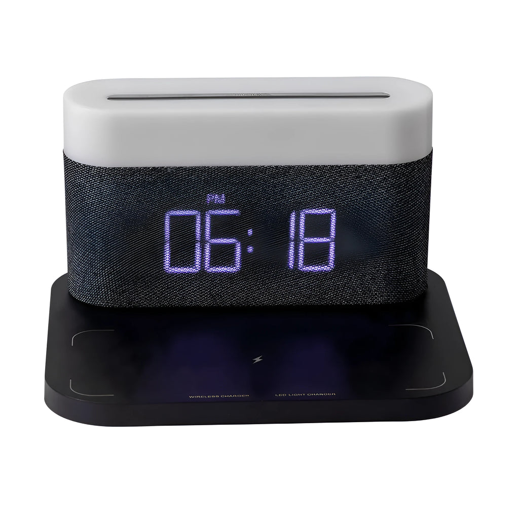 A compact black wireless charging table lamp with a digital clock display and integrated night light on a wooden desk.