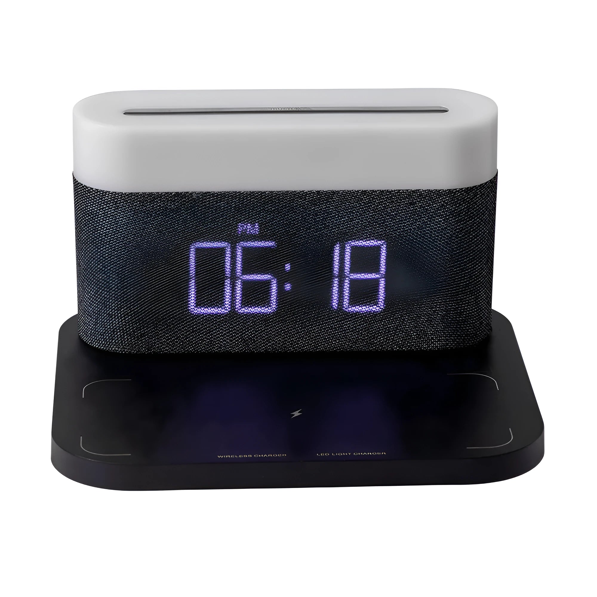 A compact black wireless charging table lamp with a digital clock display and integrated night light on a wooden desk.