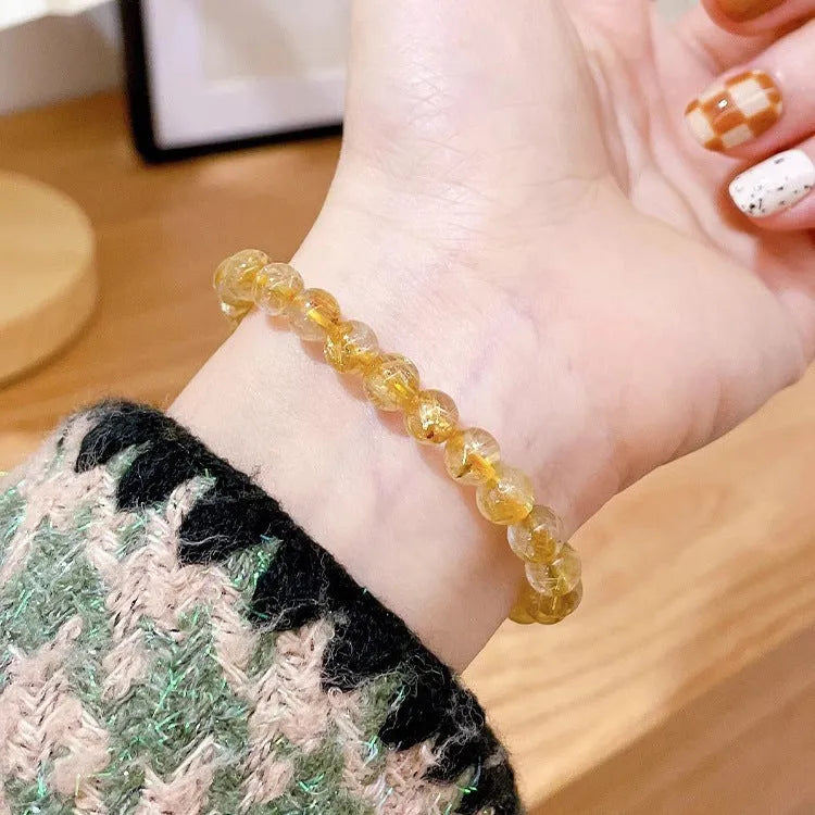 Women's gold rutilated quartz sunstone crystal bracelet with round beads in diamond pattern
