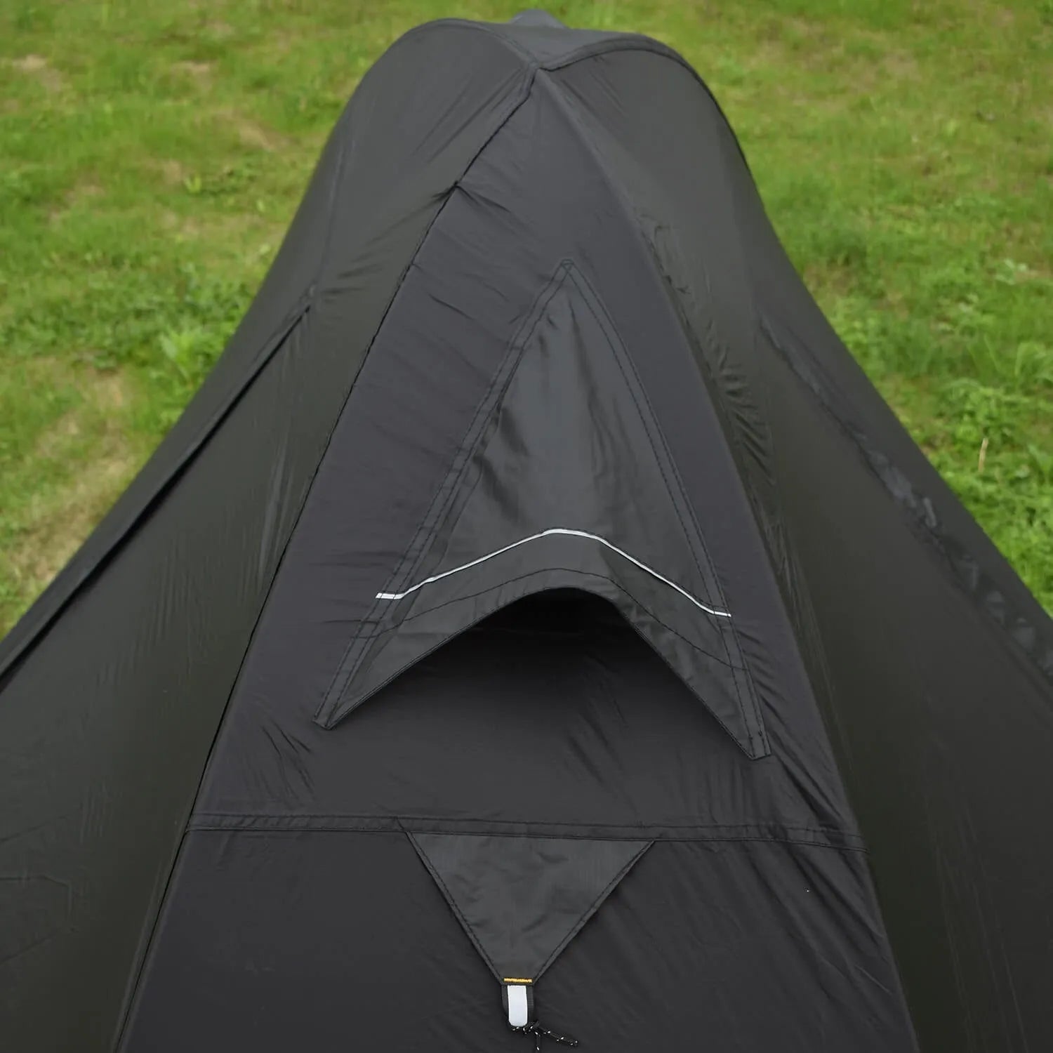 Red single person backpacking tent with aluminium poles pitched outdoors.