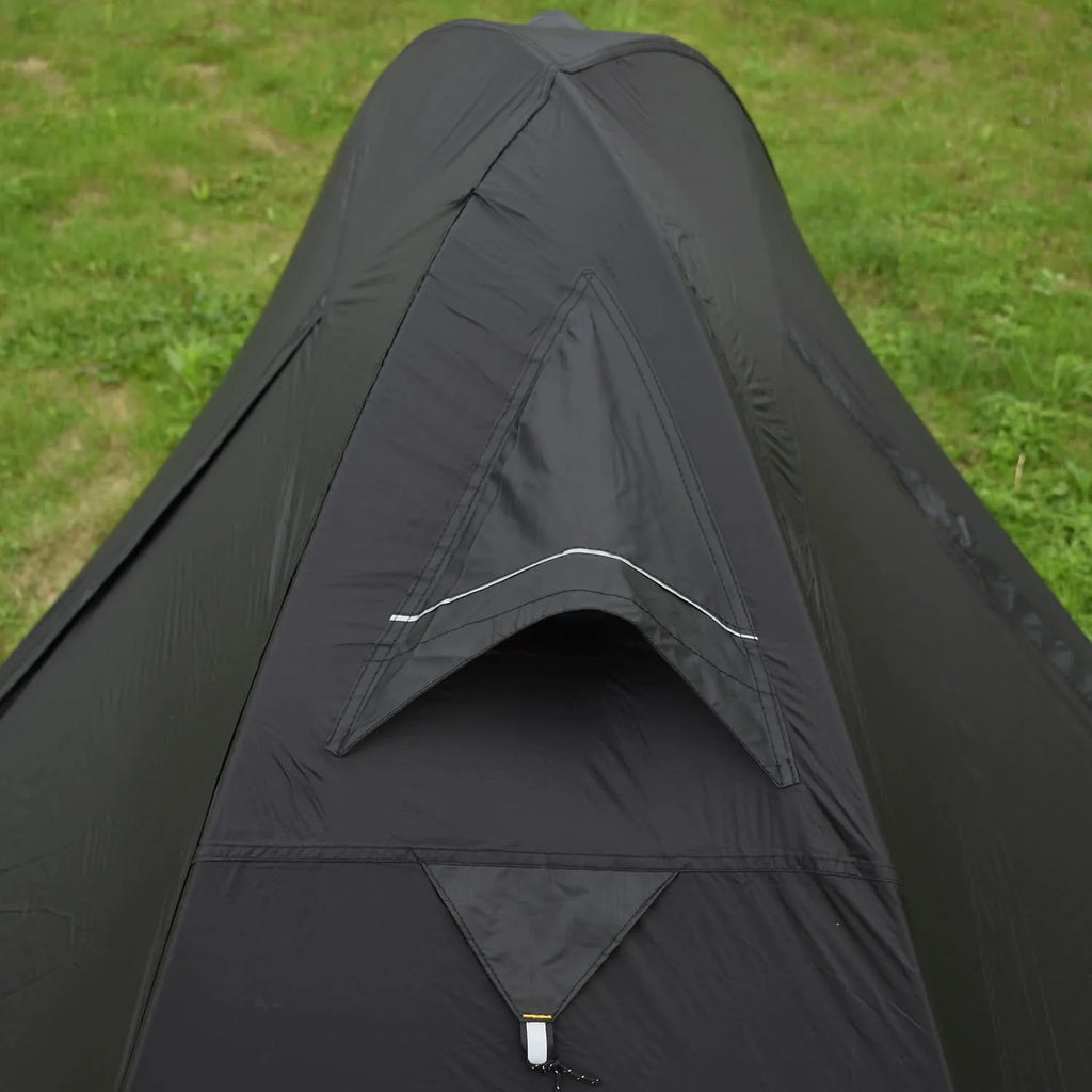 Red single person double-layer tent with aluminium poles set up outdoors.