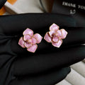 Close-up of a purple oil-spot glaze flower stud earring with a gold-plated needle on a copper base.