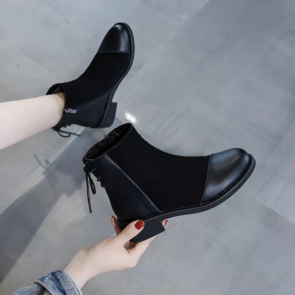 Women's black Martin boots with side zipper, non-slip rubber soles, and decorative bow detailing