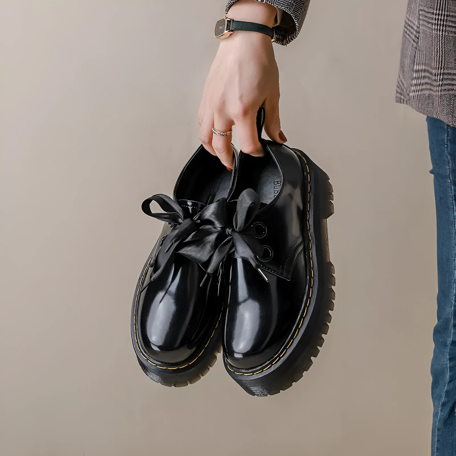 Women's black and white lace-up shoes with thick soles, ribbon details, and cross straps.