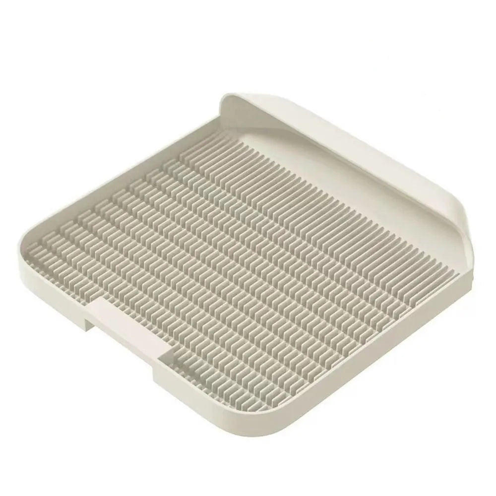 Large black cat litter pedal mat with textured grooves, placed next to a litter box.