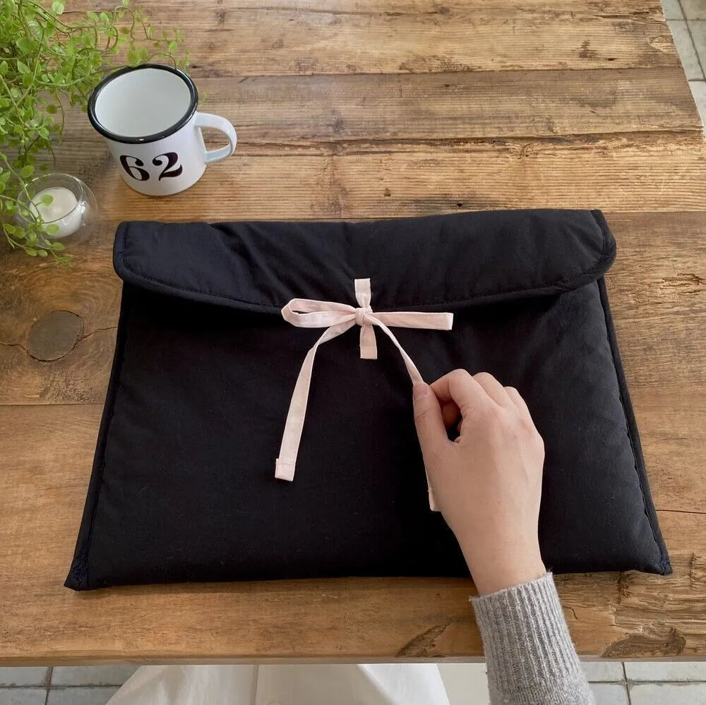 Women's black quilted laptop bag with bow detail and striped lining for 13-inch computers