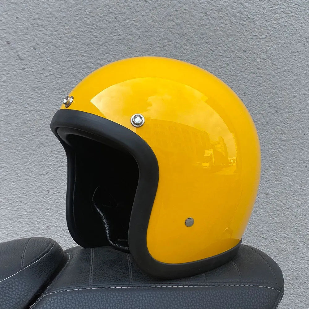 Retro-style open face motorcycle helmet in fibreglass, shown in a selection of colours including cement grey and matte black.