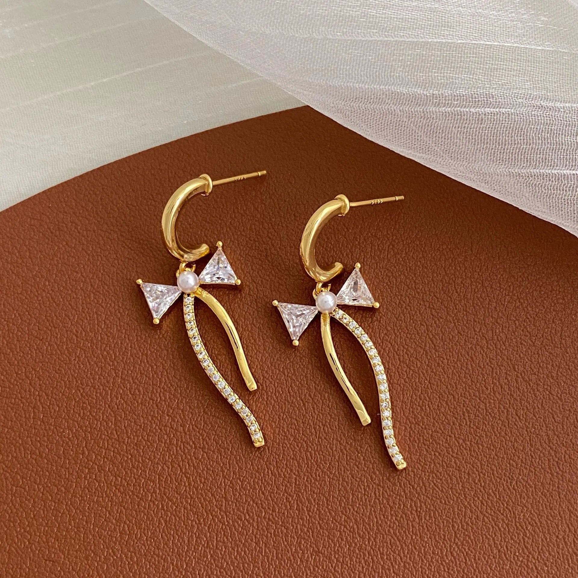 Asymmetric micro-set zirconia C-shaped light luxury earrings in copper, ear clip style on a woman