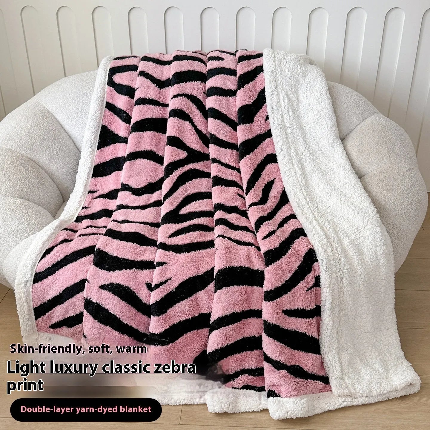 Double-layer taffeta blanket with reversible leopard jacquard print in camel colour, laid over a sofa.