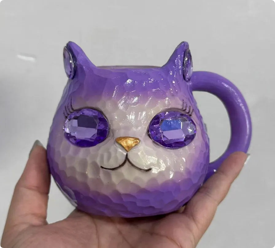 American-style resin ornament of a cat holding a crystal Earth globe in blue, green, pink, or purple.