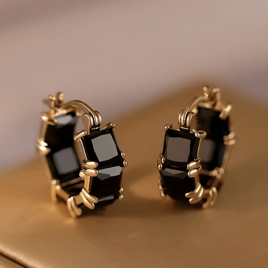 Geometric U-shaped gold earrings with a round black crystal zircon stone.