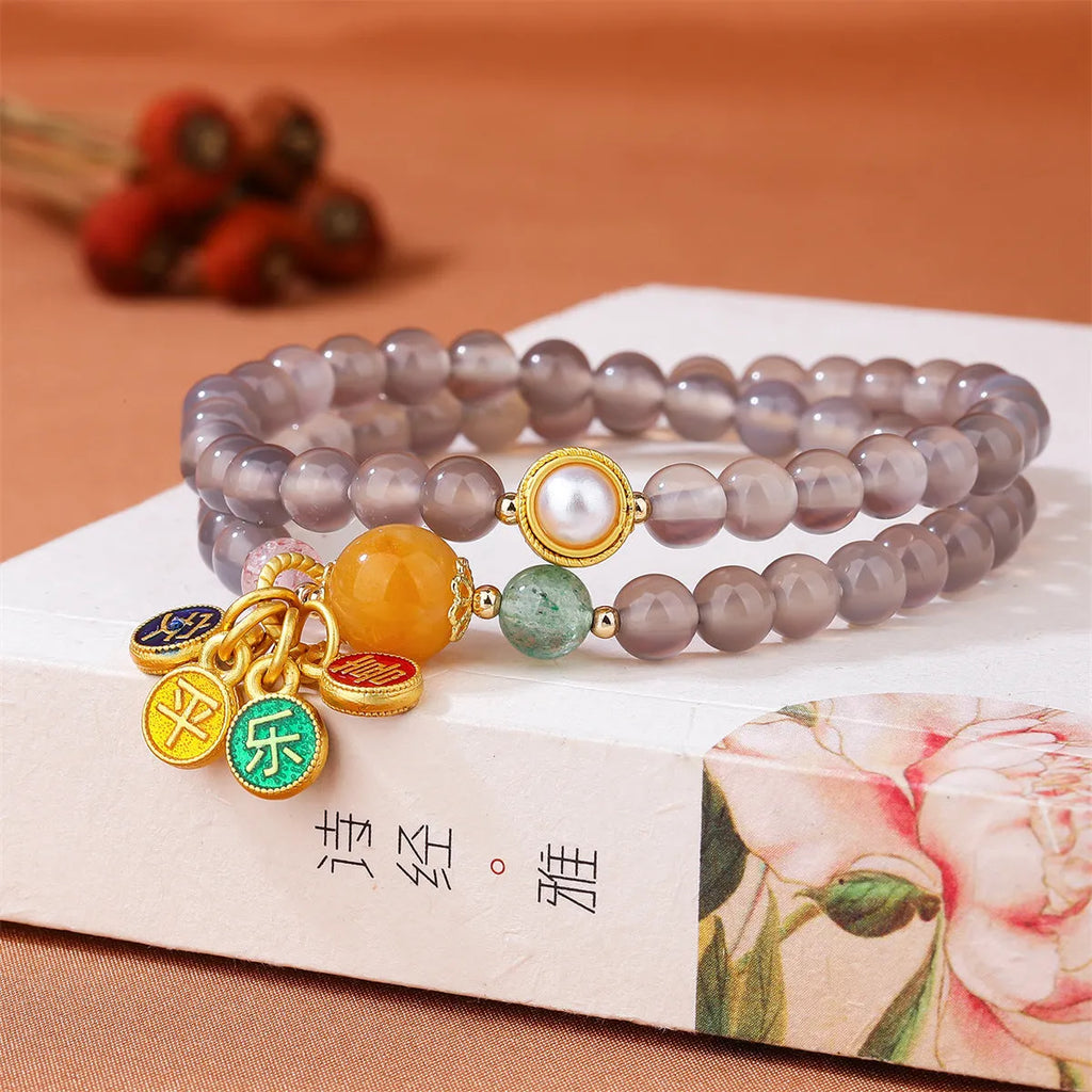 Natural gray agate two-circle bracelet on an adjustable cord, showing hand-polished stone detail.