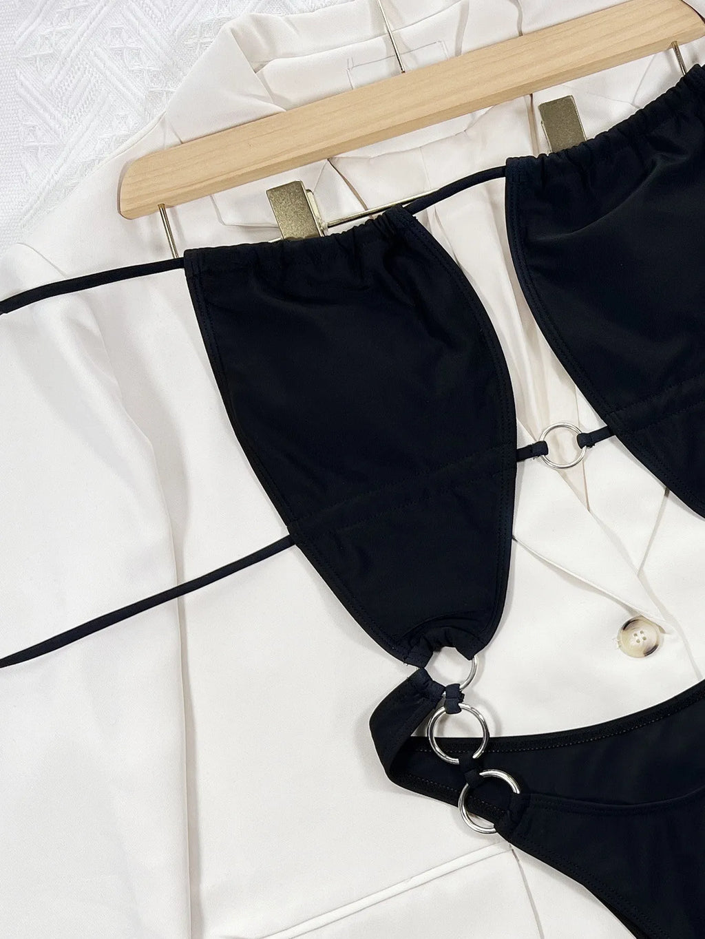 Black solid colour women's one-piece sleeveless swimsuit on hanger