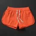 Men's loose polyester beach trousers in orange, fluorescent green, and black on a size chart