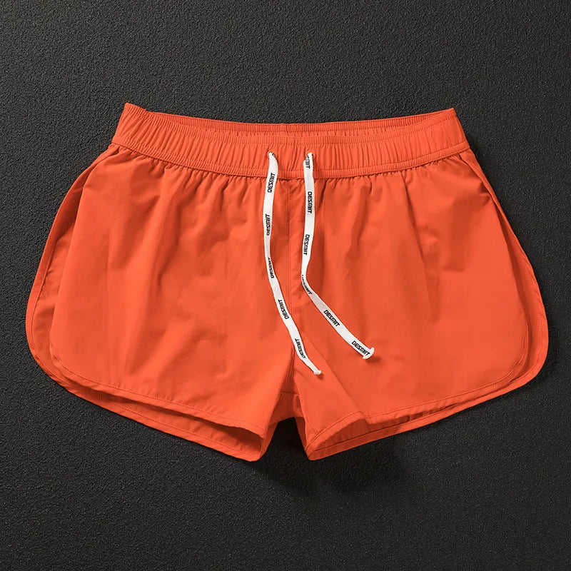 Men's loose polyester beach trousers in orange, fluorescent green, and black on a size chart