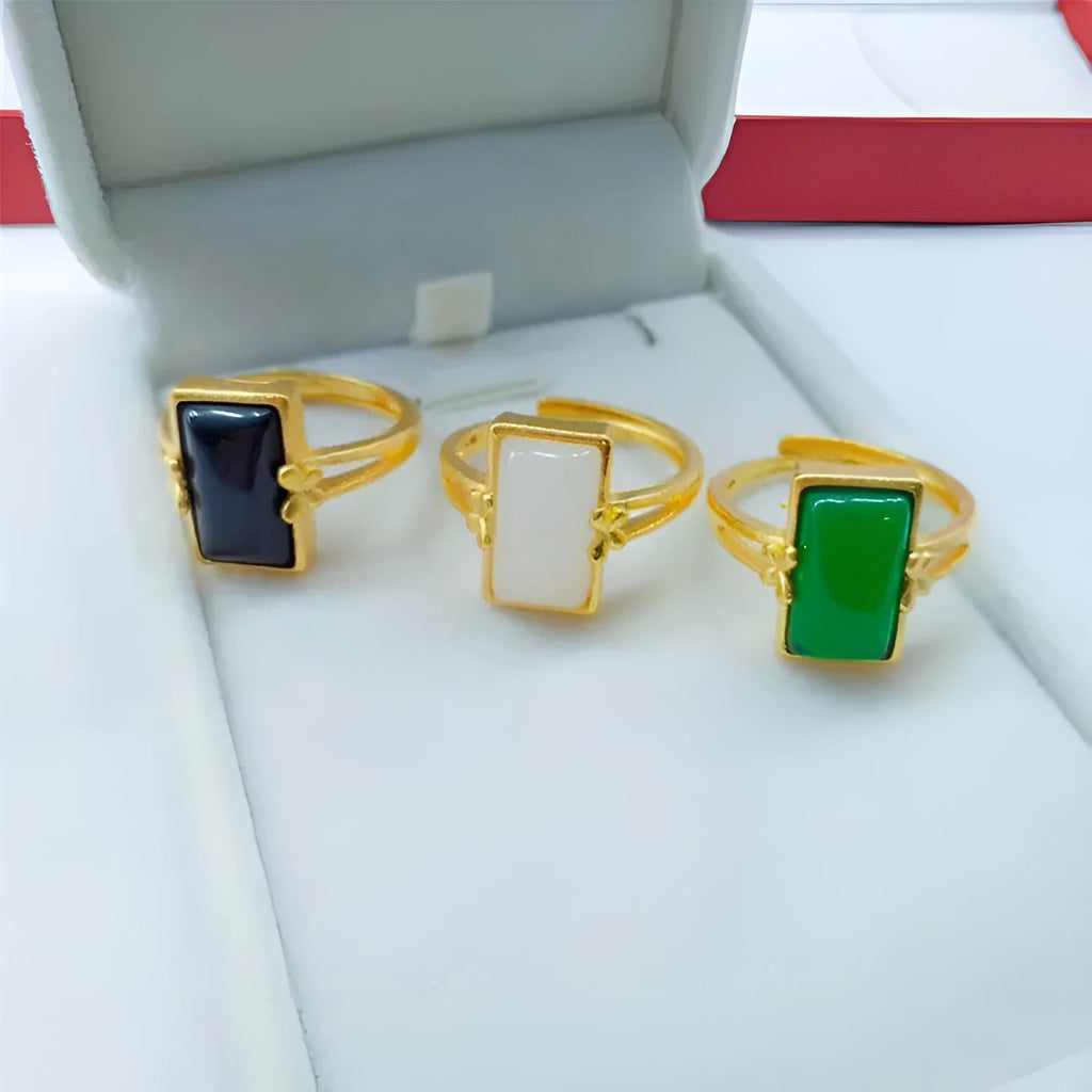 Adjustable gold plated brass ring with a national style design and a coloured inlaid gemstone.