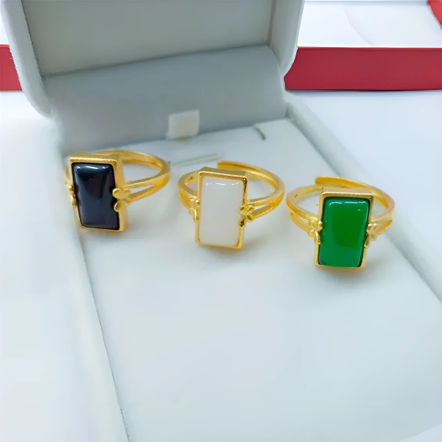 Adjustable gold plated brass ring with a national style design and a coloured inlaid gemstone.