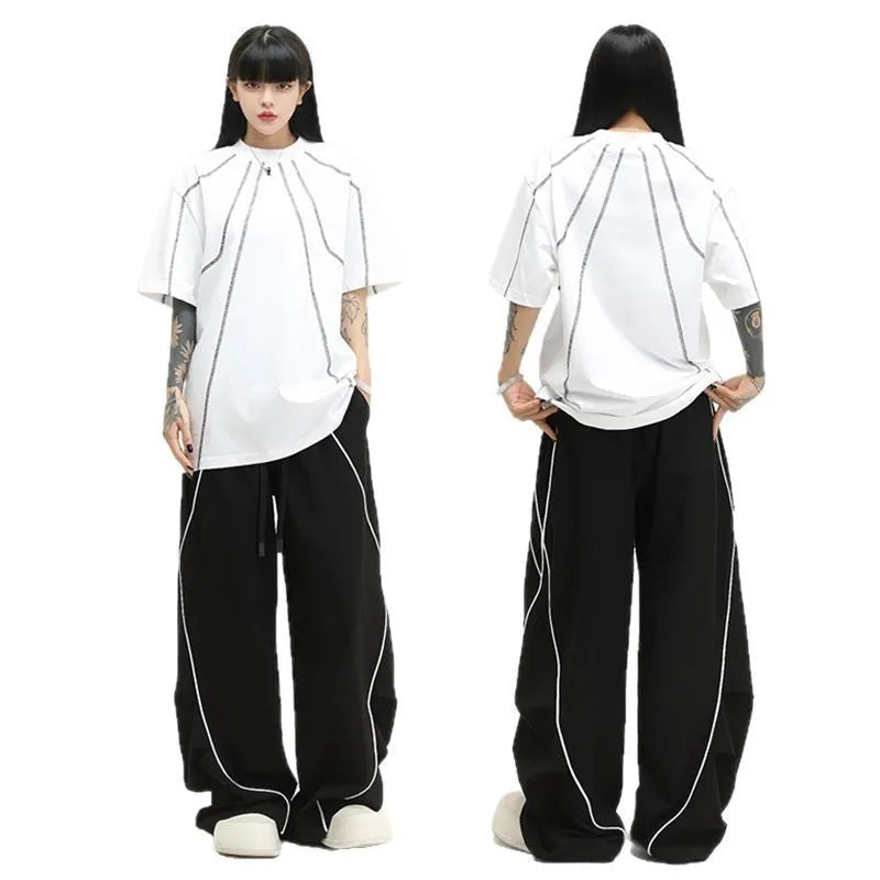 Black striped wide-leg pleated sports trousers showing loose fit and mid-waist design
