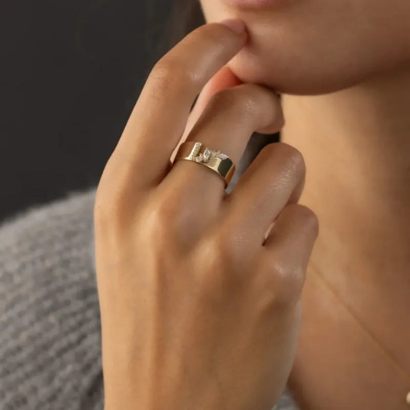 Gold electroplated copper ring with shining zircon stones on a finger.