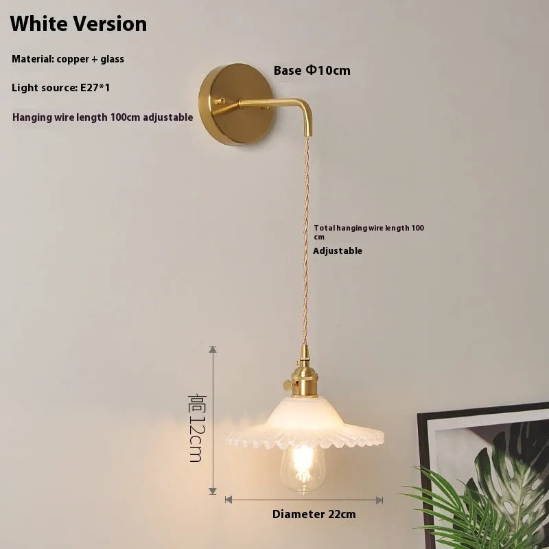 Brass-coated lotus wall lamp with a glass shade on an adjustable wire, shown in a white colour variant.