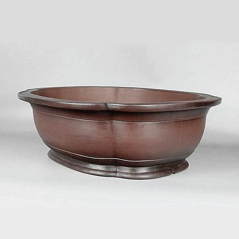Handmade antique crabapple shaped purple clay flowerpot on a floor